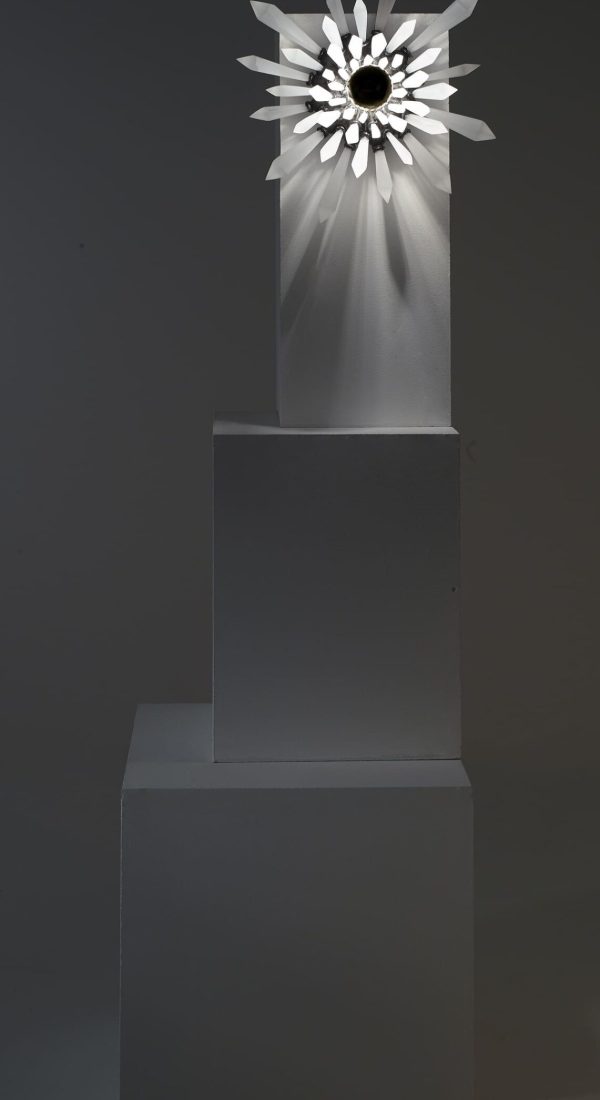 Présentation de face et entière de la sculpture lumineuse Carbon Rock Wall Light, allumée et dans le noir